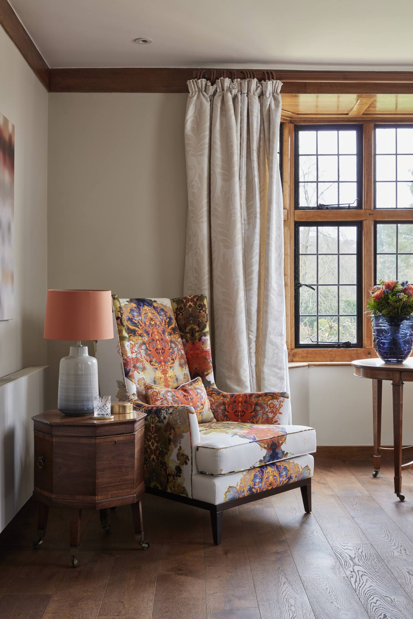 Elegant reading nook with a bold patterned armchair in a luxury Surrey countryside home.