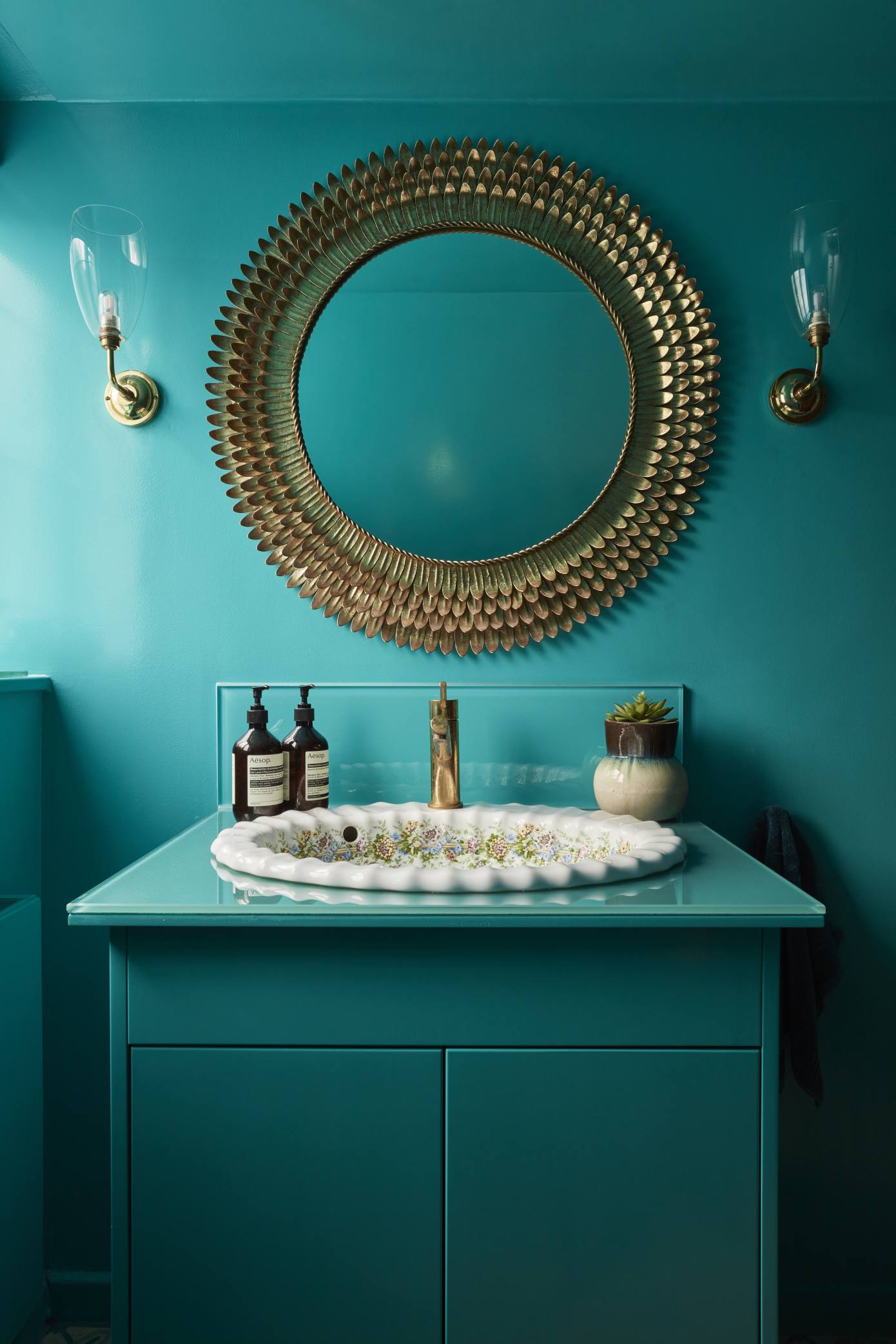 Elegant bathroom vanity with a scalloped basin and gold accents in a striking blue and gold colour scheme.