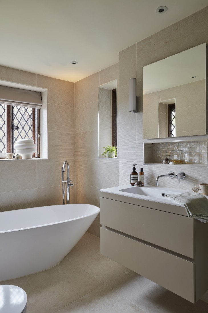 Minimalist vanity area with a modern sink, large mirror, and soft lighting.