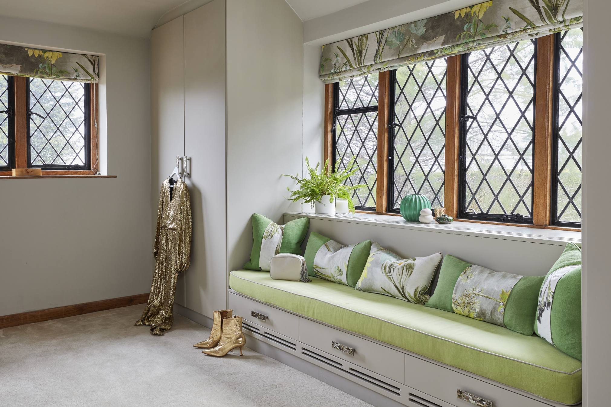 Bespoke dressing area with built-in seating and soft green cushions.