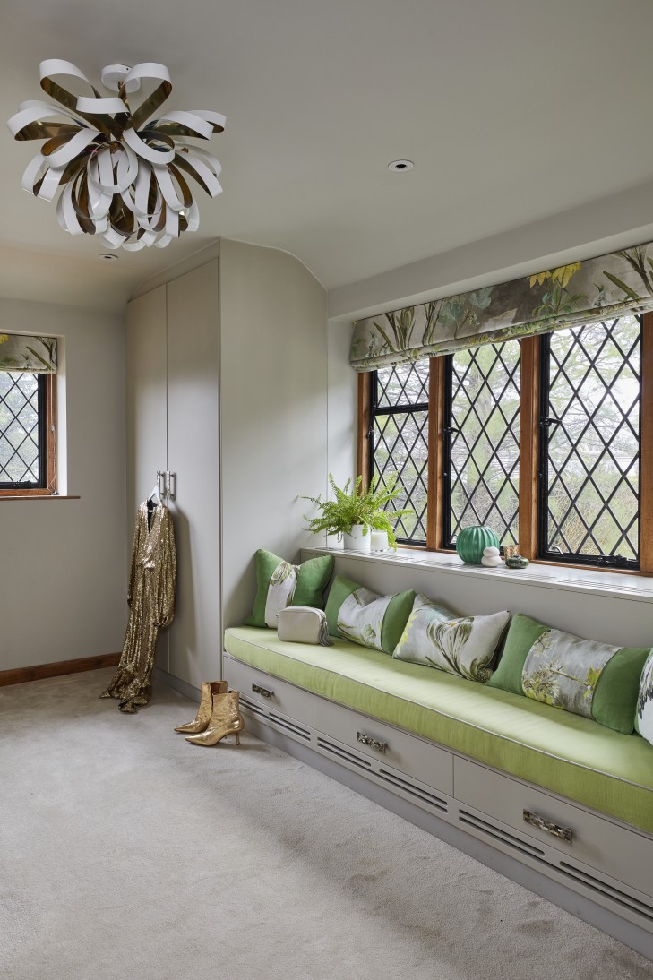 Elegant dressing area with custom cabinetry, plush bench seating, and decorative elements.