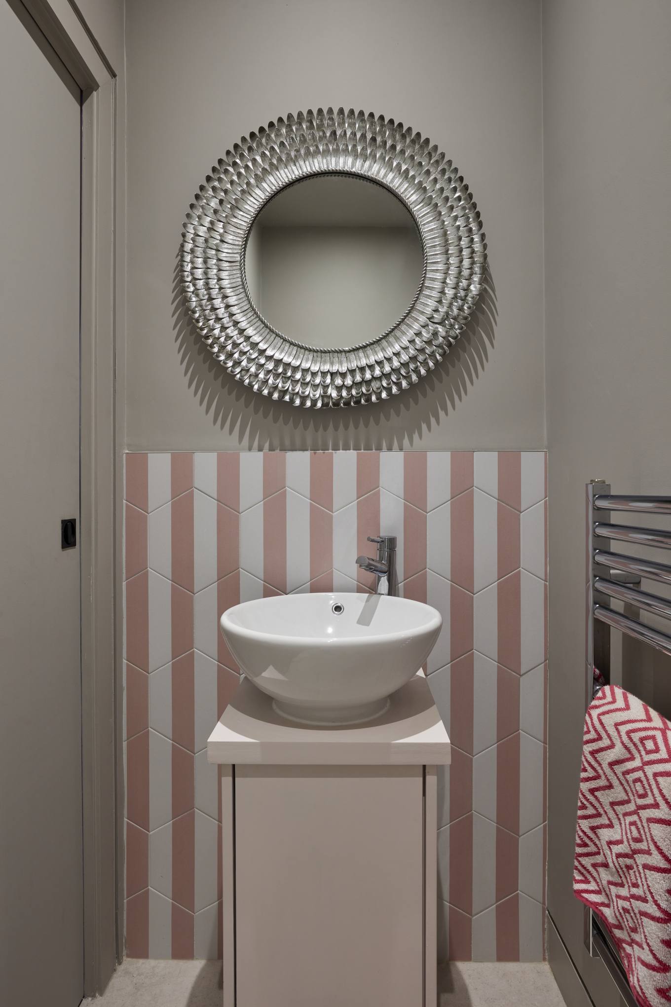 Luxury guest powder room in the pool house with a statement mirror and pink geometric tiles